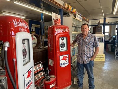 Ross standing next to old gas pumps